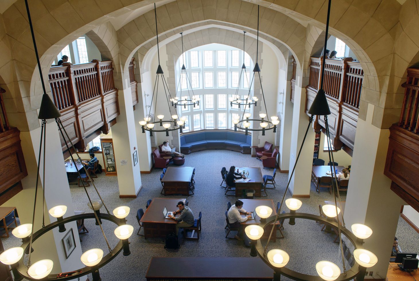 Bird's eye image of inside of library with students studying at desks. 
